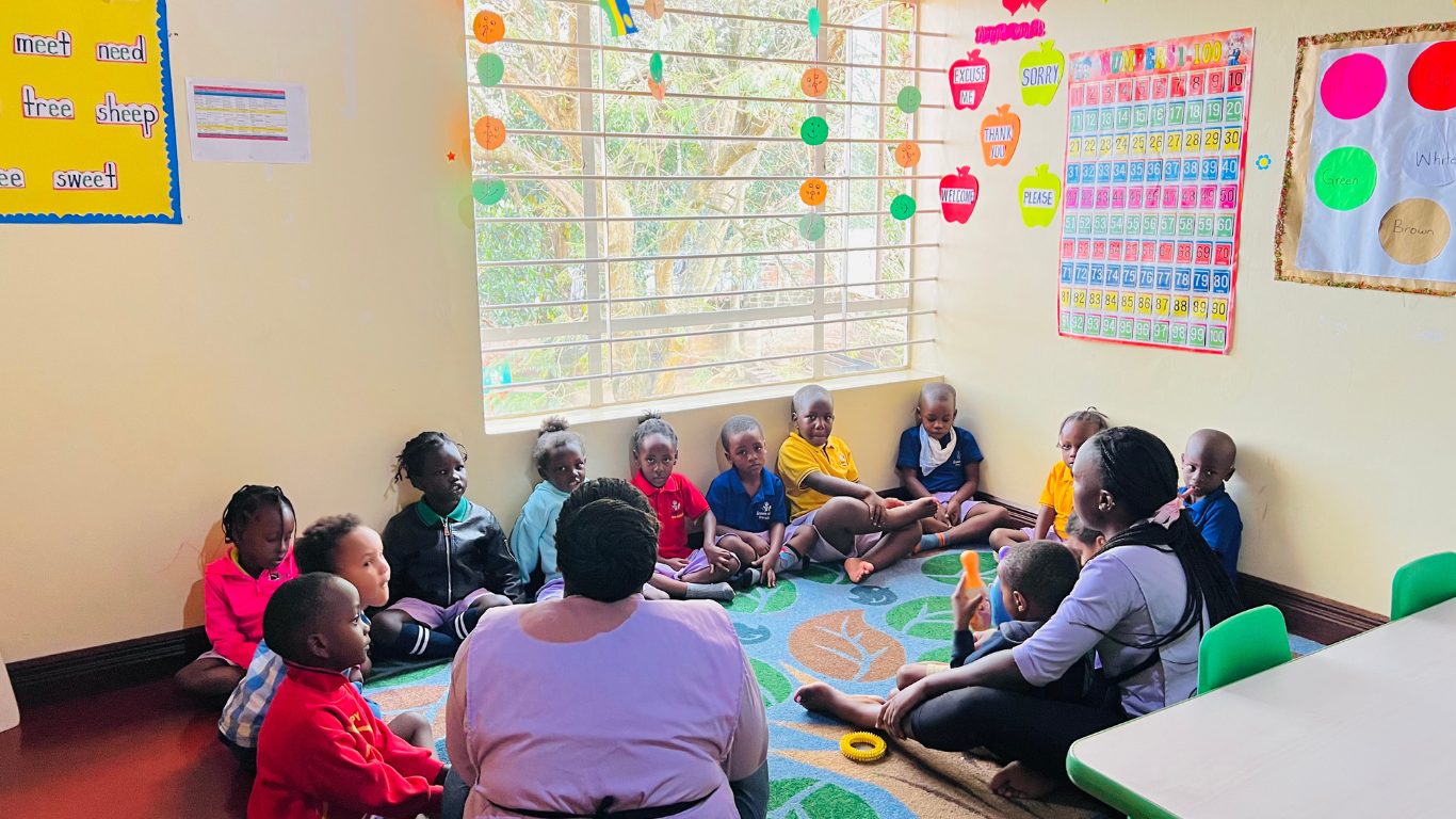 Play Group children sitting in a circle with teachers